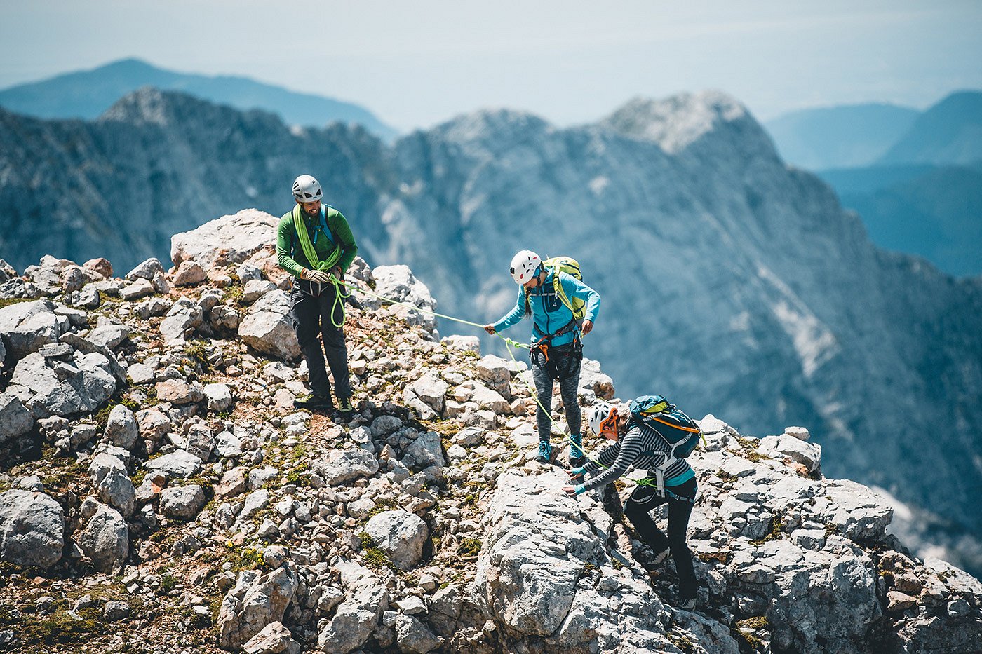 Gli escursionisti scalano la montagna in attrezzatura da alpinismo completo