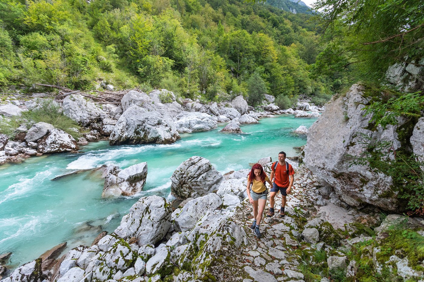 Hikers walk along the Juliana Trail along the emerald Soča River