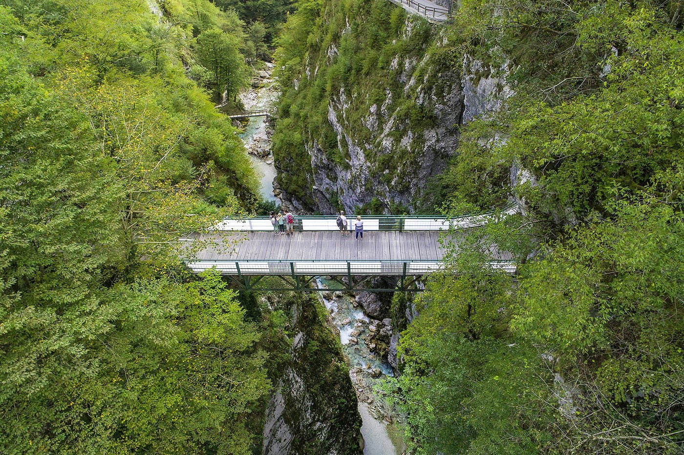 Visitors look from the Devil\'s Bridge 60 m deep into the Tolminka gorge.