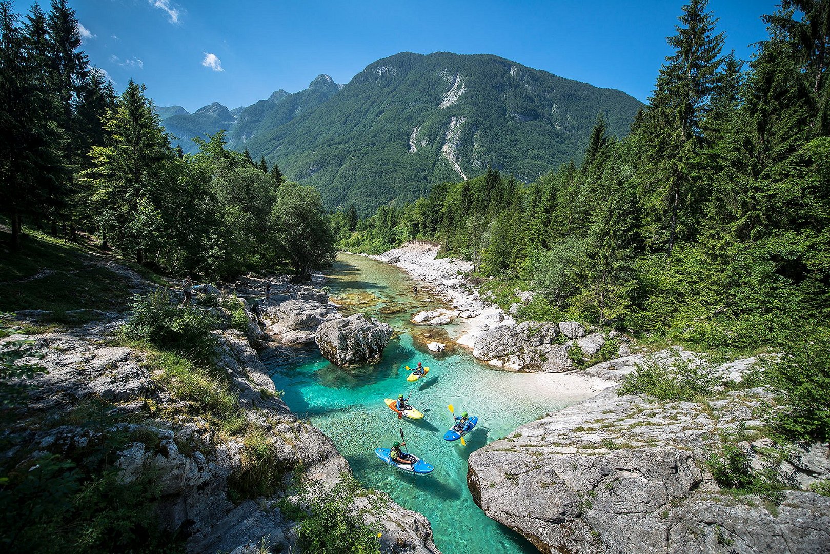 A group of kayakers on the emerald river Soča in the Triglav National Park