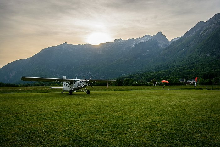 Letalo parkirano na letališču obdanim s hribi