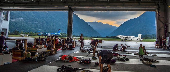 Fallschirmspringer im Hangar bereiten vor dem Sprung Fallschirme vor