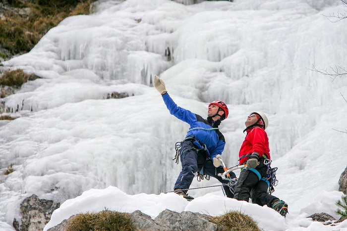 Equipped climbers enjoy the view from the icy waterfall