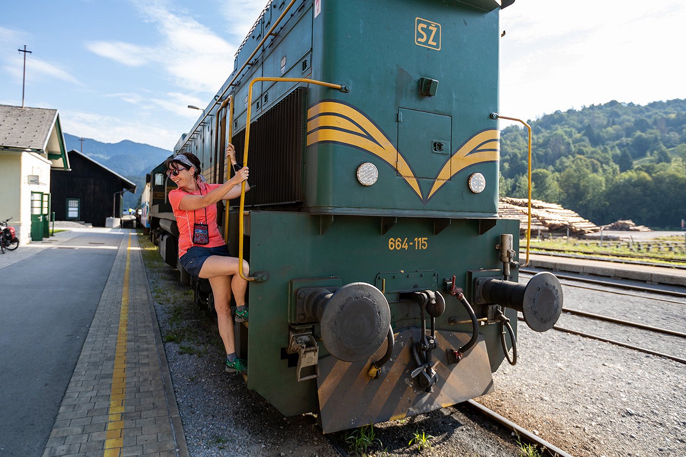 Una passeggera sorridente sale su un treno alla stazione ferroviaria.