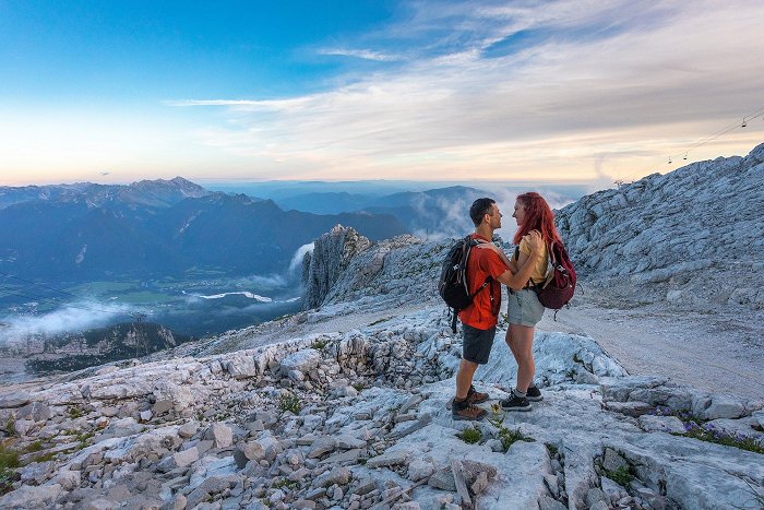 La coppia gode romanticamente sulla montagna Kanin al tramonto con vista sulla valle