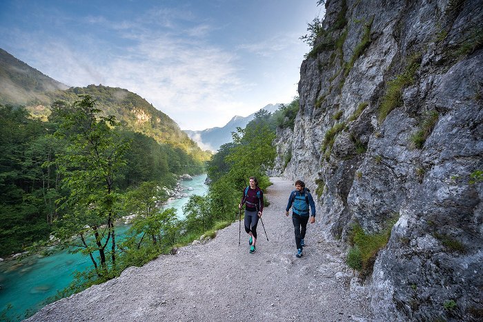 Wanderer wandern auf dem Juliana Trail entlang des smaragdgrünen Flusses Soča