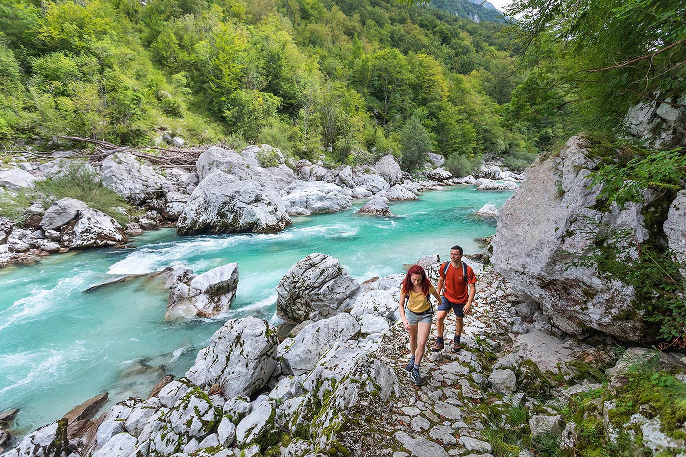 Wanderer wandern auf dem Juliana Trail entlang des smaragdgrünen Flusses Soča