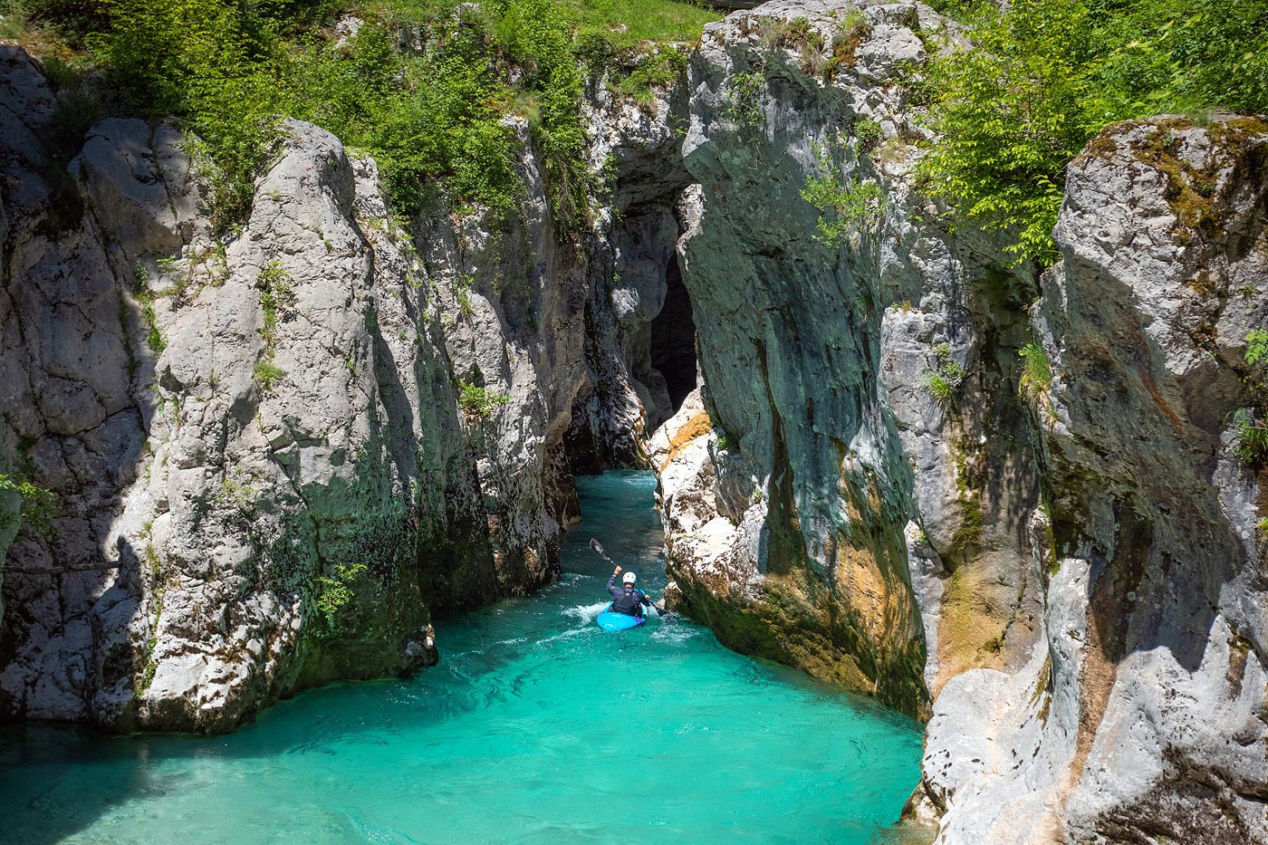 The kayaker paddles upstream towards the Great Soča Gorge
