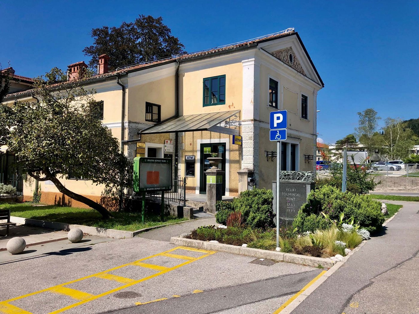 the building of the Tolmin Tourist Information Centre in the centre of Tolmin, in front of which is a parking lot for the disabled