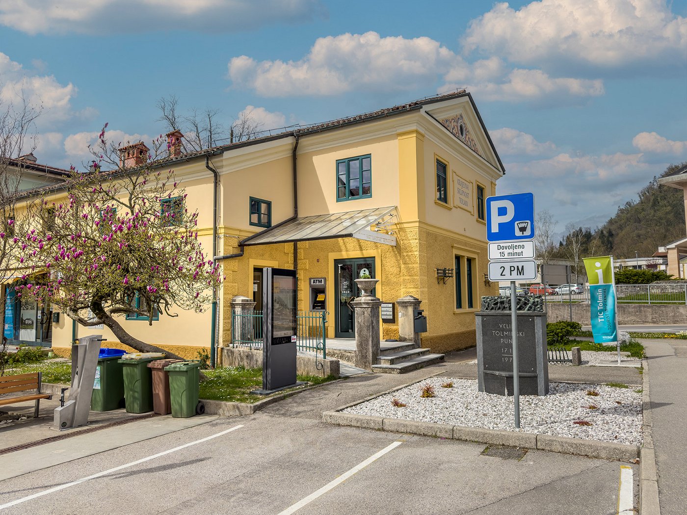 l\'edificio del Centro Informazioni Turistiche di Tolmin nel centro di Tolmin, davanti al quale c\'è un parcheggio per 15 min