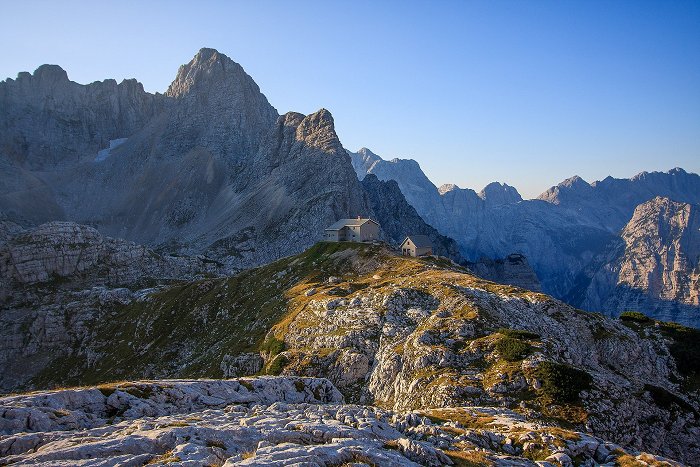 View of Pogačnikov dom mountain hut with mountains in the background