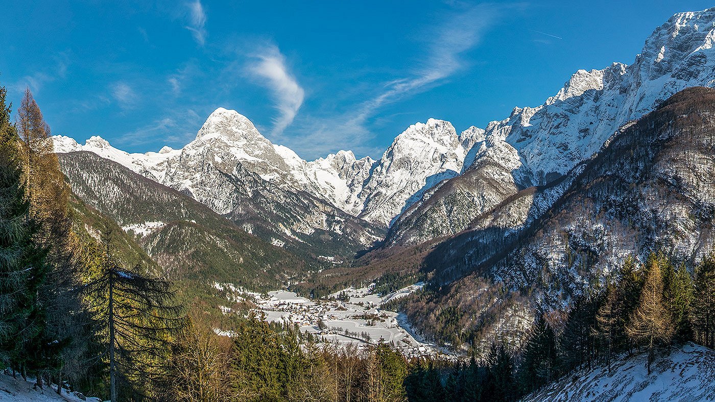 Pogled na zasneženo dolino pod goro Mangart in Loško steno.